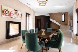 een eetkamer met een tafel en groene stoelen bij Villa les Palmiers in Marrakesh