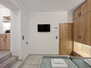 a bedroom with a bed and a tv on a wall at Myrsini Rooms in Mytilini