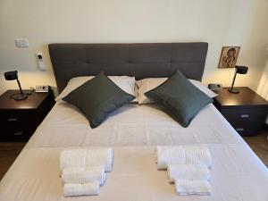a large bed with two pillows on it with two tables at Giopi Home in Vitinia