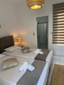 two twin beds in a room with a bathroom at Chrysa House in Kamares