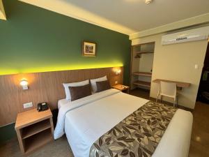 una camera d'albergo con un grande letto e una parete verde di El Tambo 1 a Lima