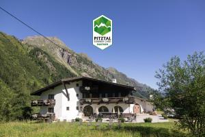 duży biały budynek z górą w tle w obiekcie Natur Residenz Anger Alm - Adults only w mieście St. Leonhard im Pitztal