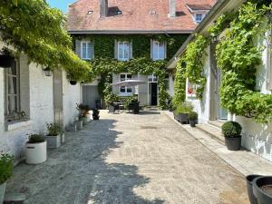 a courtyard of a house with potted plants at L'Auberge du Château in Tilloloy