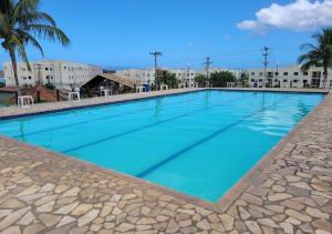 a large swimming pool with blue water at Apartamendo Marina Clube in São Pedro da Aldeia