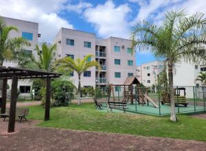 a playground in front of a large building at Apartamendo Marina Clube in São Pedro da Aldeia