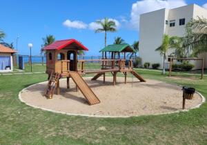 a playground with two play equipment in a park at Apartamendo Marina Clube in São Pedro da Aldeia