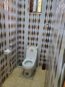 a bathroom with a white toilet in a room at 2M Tarangire Lodge in Kwa Kuchinia