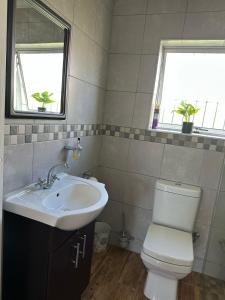 a bathroom with a sink and a toilet and two windows at Casa Da Gama Luxe in Marina Da Gama +9 photos