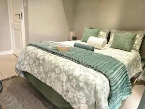 a bedroom with a bed with a green and white comforter at The Barn Haven in Kyalami