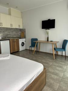 a room with a bed and a table and a tv at Aqua Batumi 39 in Batumi