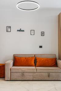 a couch with orange pillows in a room at Relax Seafront Apartment by PS in Golem