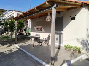 a patio with a wooden pergola and a table at Io's Guest House in Ofrínion
