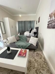 a living room with a couch and a bed at Sunningdale White House Accomodations in Cape Town