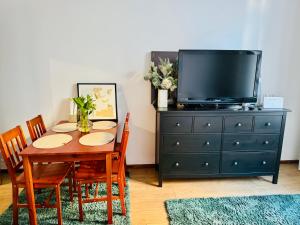 a dining room with a table with a tv and a dresser at Mazurska in Barczewo