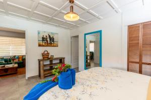 a bedroom with a bed with a blue bag of flowers on it at Aruba Casita Arashi in Noord