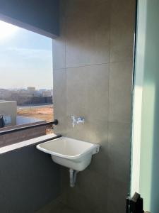un lavandino bianco in un bagno con finestra di Kitnet equipada pra descansar a Votuporanga