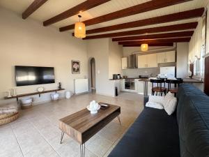 a living room with a couch and a table at Lithos Apartment in Artemida