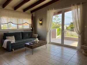 a living room with a couch and a table at Lithos Apartment in Artemida