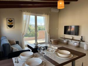 a living room with a table with wine glasses on it at Lithos Apartment in Artemida