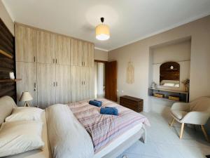 a bedroom with a large bed and a chair at Lithos Apartment in Artemida