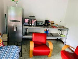 kuchnia z czerwonym krzesłem i zlewem w obiekcie Monkey View w mieście Puerto Viejo +5 zdjęć