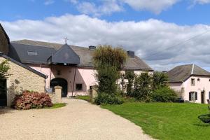 a large pink house with a driveway in a yard at Au Petit Bercail - Le Loft - Gite pour 4 personnes in Chiny