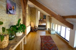 a large living room with a stone wall at Au Petit Bercail - Le Loft - Gite pour 4 personnes in Chiny