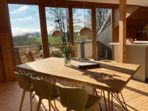 tavolo e sedie in cucina con ampia finestra di It's Gunneby nice - Ferienwohnung a Ulsnis