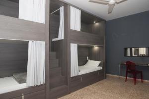a bedroom with two bunk beds and a desk at Quart Youth Hostel & Apartments in Valencia