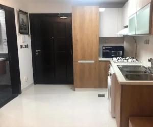 a kitchen with a sink and a black door at Glamz studio staycation Dubai in Sabkhah