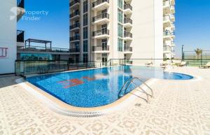 a large swimming pool in front of a building at Glamz studio staycation Dubai in Sabkhah