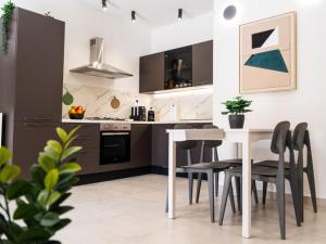a kitchen with a table and black chairs at Pellarhome Quality Guest House in Pellaro