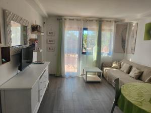 a living room with a couch and a television at casa Sun&Sand Corralejo in Corralejo