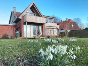 una casa con fiori bianchi nel cortile di It's Gunneby nice - Ferienwohnung a Ulsnis