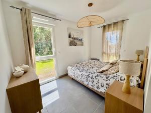 a bedroom with a bed and a large window at Appartement 2 chambres à 600m de l'Océan in Mimizan-Plage