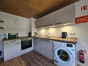 een keuken met een wasmachine en een wasmachine bij SIM01 Renovierte Monteurs- und Ferienwohnung in Simmerath in Simmerath