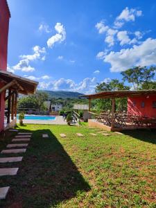 a yard with a swimming pool and a house at Chalé Bella Serra piscina café da manhã incluso in Jaboticatubas