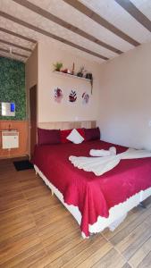 a bedroom with a large red bed in a room at Chalé Bella Serra piscina café da manhã incluso in Jaboticatubas