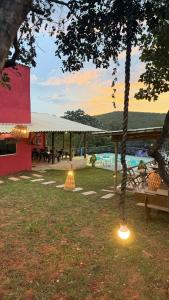 a patio with a hammock and a swimming pool at Chalé Bella Serra piscina café da manhã incluso in Jaboticatubas +7 photos