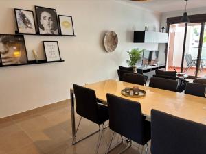 a dining room with a wooden table and chairs at Salinalux Vera Playa in Vera