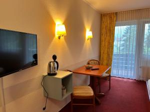 a hotel room with a table and a television at Gästehaus Tilly in Hannoversch Münden