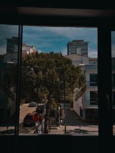 a window view of a street with a tree and buildings at El Mare Hotel and Restaurant in Durrës
