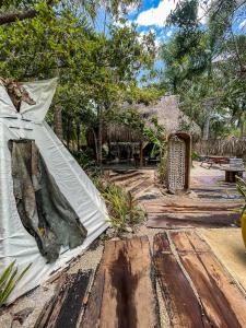 ein Garten mit einem weißen Sonnenschirm auf einem Holzboden in der Unterkunft Sanctuary Bacalar in Bacalar