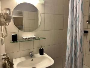 a bathroom with a sink and a mirror at Gästehaus Tilly in Hannoversch Münden