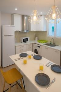 a kitchen with a table with plates and glasses on it at Avenida del Mar 14 Junio in Castellón de la Plana