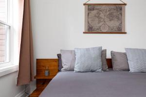 un lit avec des oreillers et une carte au mur dans l'établissement All Season Muskoka Cottage, à Huntsville