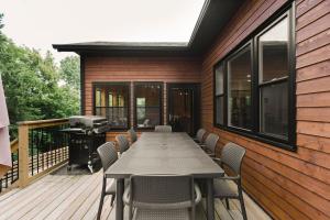 une table et des chaises sur une terrasse avec un grill dans l'établissement All Season Muskoka Cottage, à Huntsville