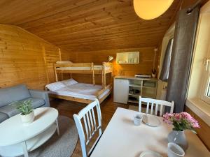 a living room with a table and a kitchen and a bunk bed at Cozy Camping Cabin in Hjelmeland