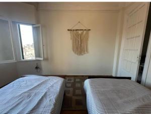 two beds in a room with a window at Agora House for men only 仅限男性 in Alexandria