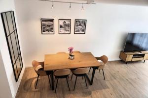 a dining room with a table and chairs and a tv at Top duplex Apartment Zurich-Limmattal in Killwangen